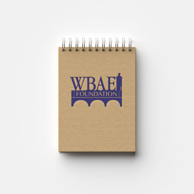 WBAEI Foundation logo designed by Ashley Carloni and placed on a notebook